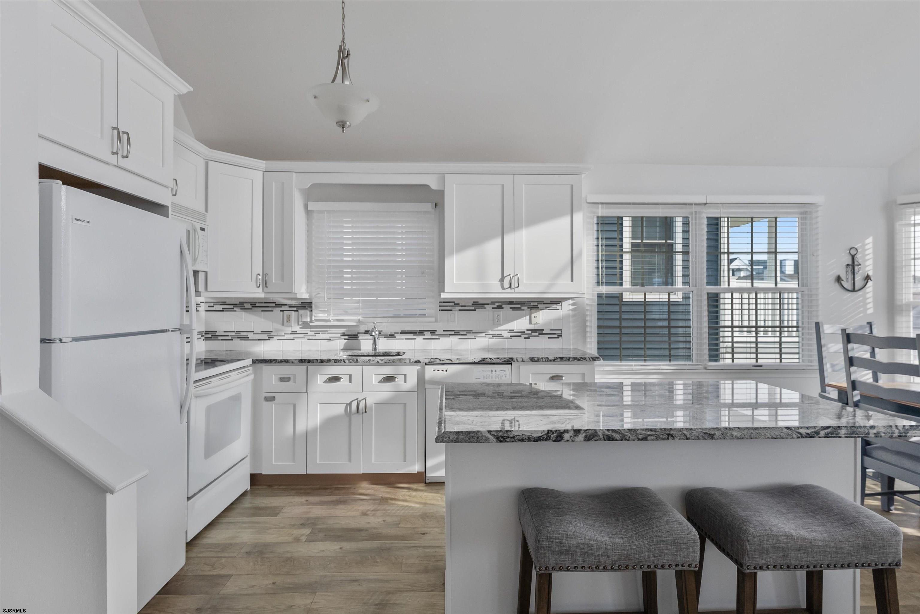 4930 Asbury Avenue, Unit 2 Ocean City, NJ 08226 - Photo 8 of 25 a kitchen with stainless steel appliances granite countertop a sink and a refrigerator