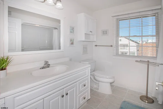 a bathroom with a toilet a sink and a large mirror