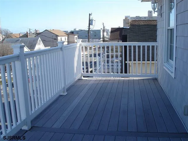 a balcony with wooden floor table and chairs