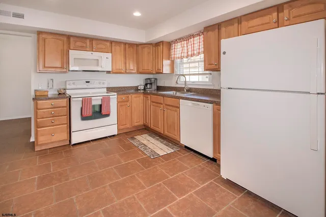 a kitchen with a stove a sink and a refrigerator