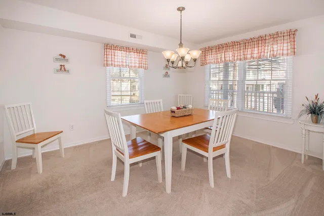 a dining room with furniture a chandelier and wooden floor