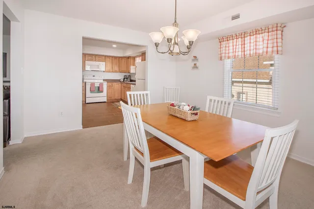 a view of a dining room with furniture and chandelier