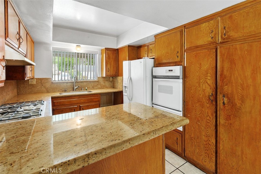 786 Spruce Street Riverside, CA 92507 - Photo 14 of 29 a kitchen with stainless steel appliances granite countertop a refrigerator and a stove