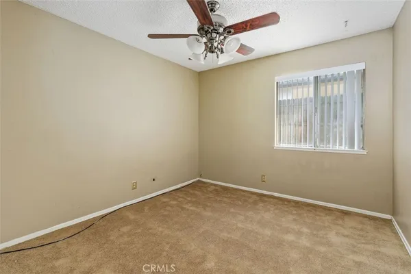 an empty room with windows and fan