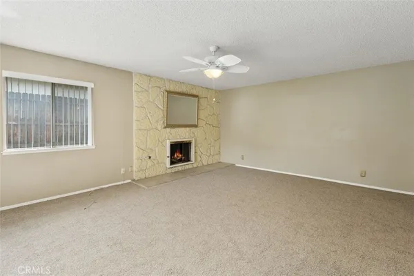 an empty room with windows and fireplace