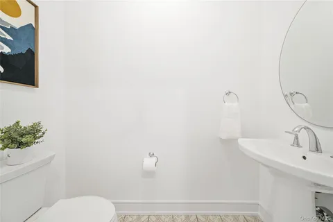 a bathroom with a sink and mirror with toilet