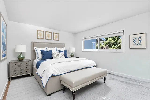 a bedroom with a bed a painting and a window