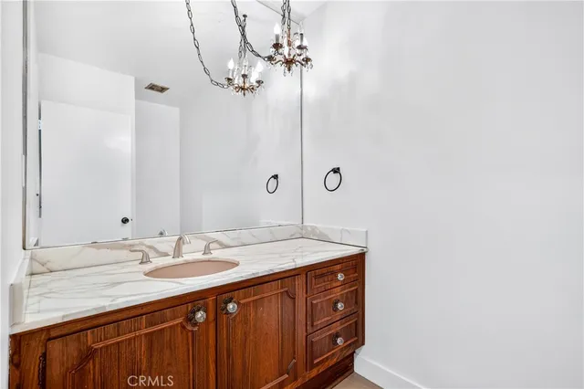 a bathroom with a sink vanity granite and a mirror