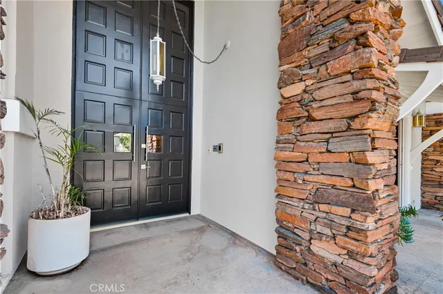 front view of a brick house with a potted plant and windows