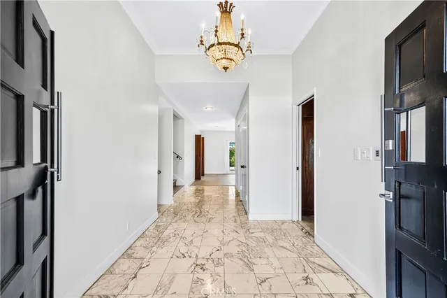 a view of hallway with chandelier and entryway