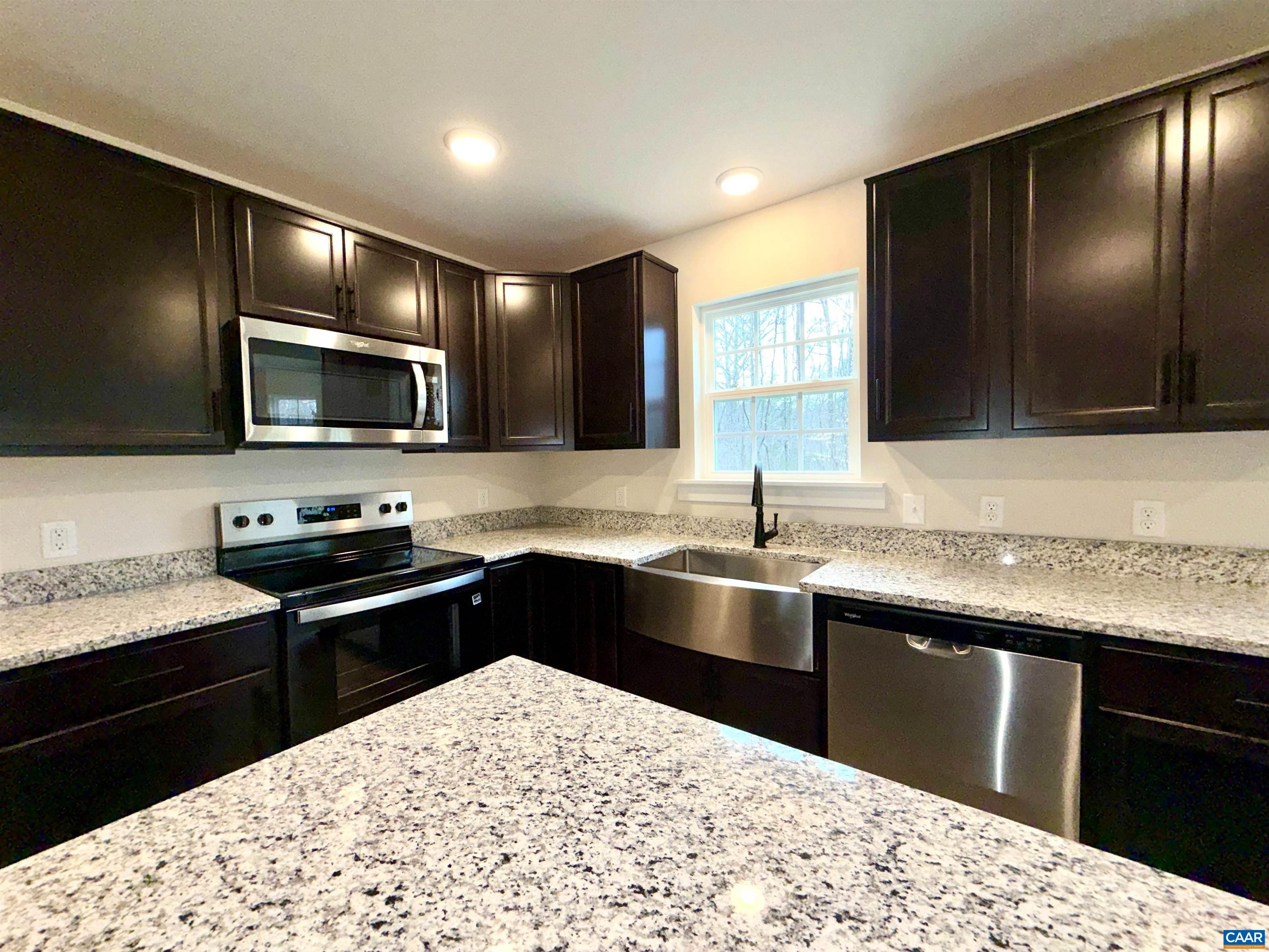 3546 Courthouse Road, Unit CBE4 Palmyra, VA 22963 - Photo 7 of 19 a kitchen with stainless steel appliances kitchen island granite countertop a sink stove and microwave