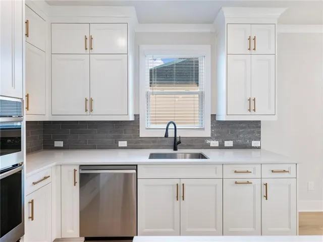 a view of an empty room with wooden floor ceiling fan
