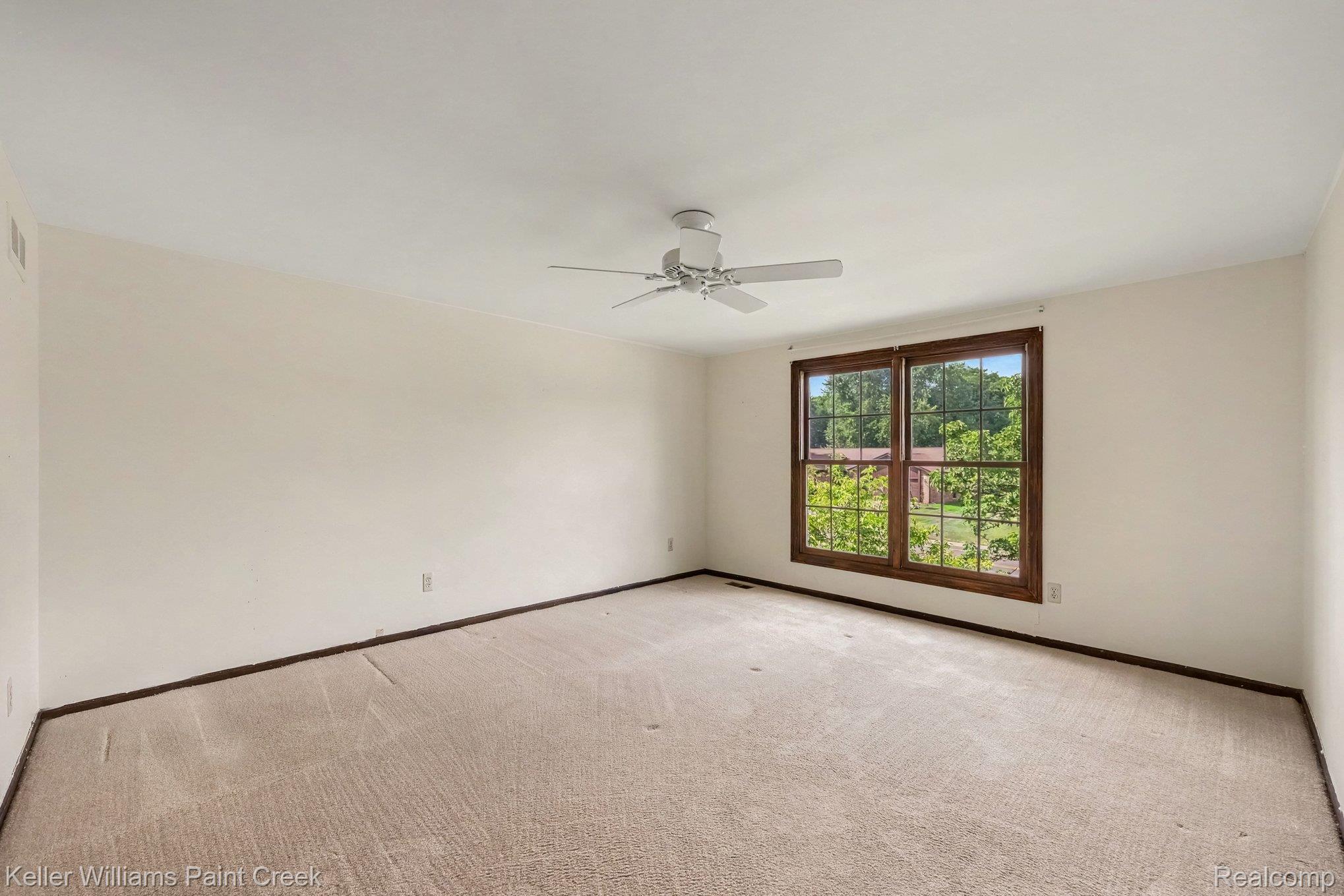 2717 Powderhorn Ridge Road Rochester, MI 48309 - Photo 21 of 48 Neutral tone wall paint, wood-framed windows, and a ceiling fan