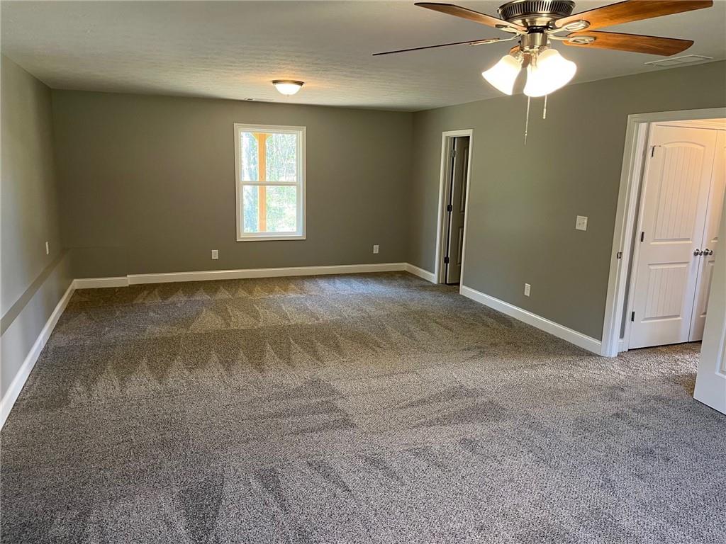 202 Gamel Road Dallas, GA 30157 - Photo 26 of 34 an empty room with a chandelier fan and windows