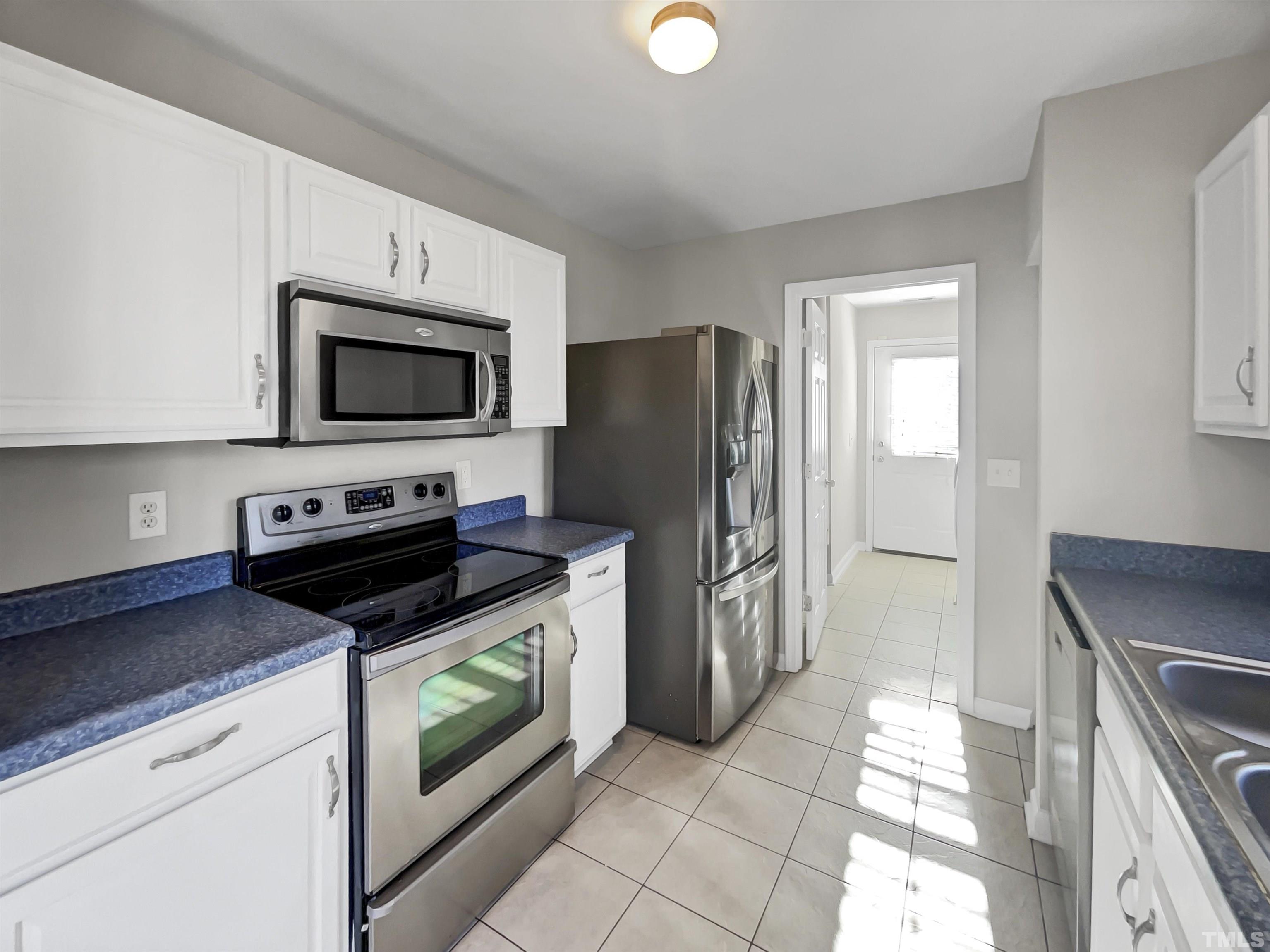 2829 Midway Park Court Raleigh, NC 27610 - Photo 11 of 16 a kitchen with a stove a microwave and a refrigerator