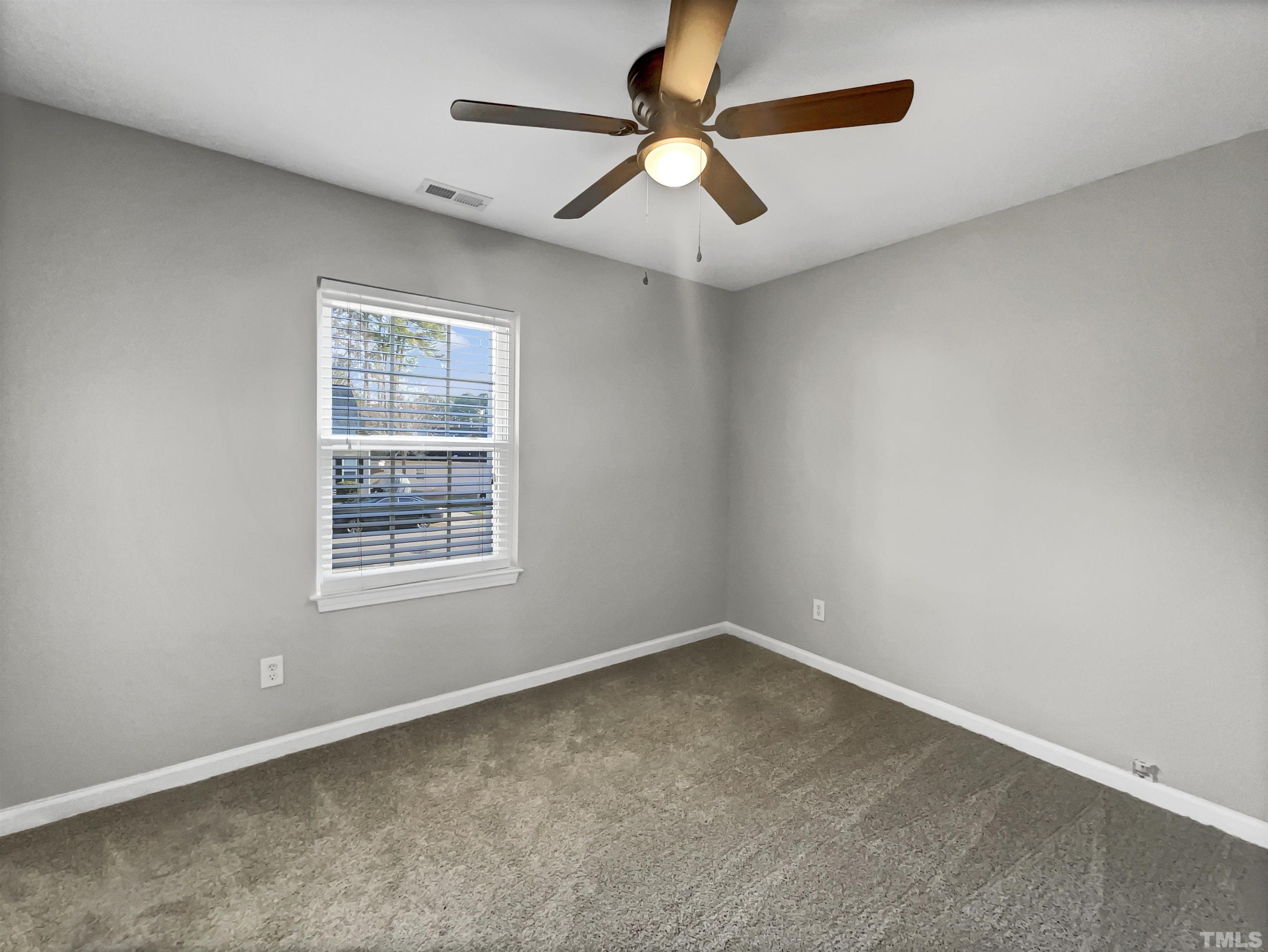 2829 Midway Park Court Raleigh, NC 27610 - Photo 5 of 16 an empty room with a window and a fan
