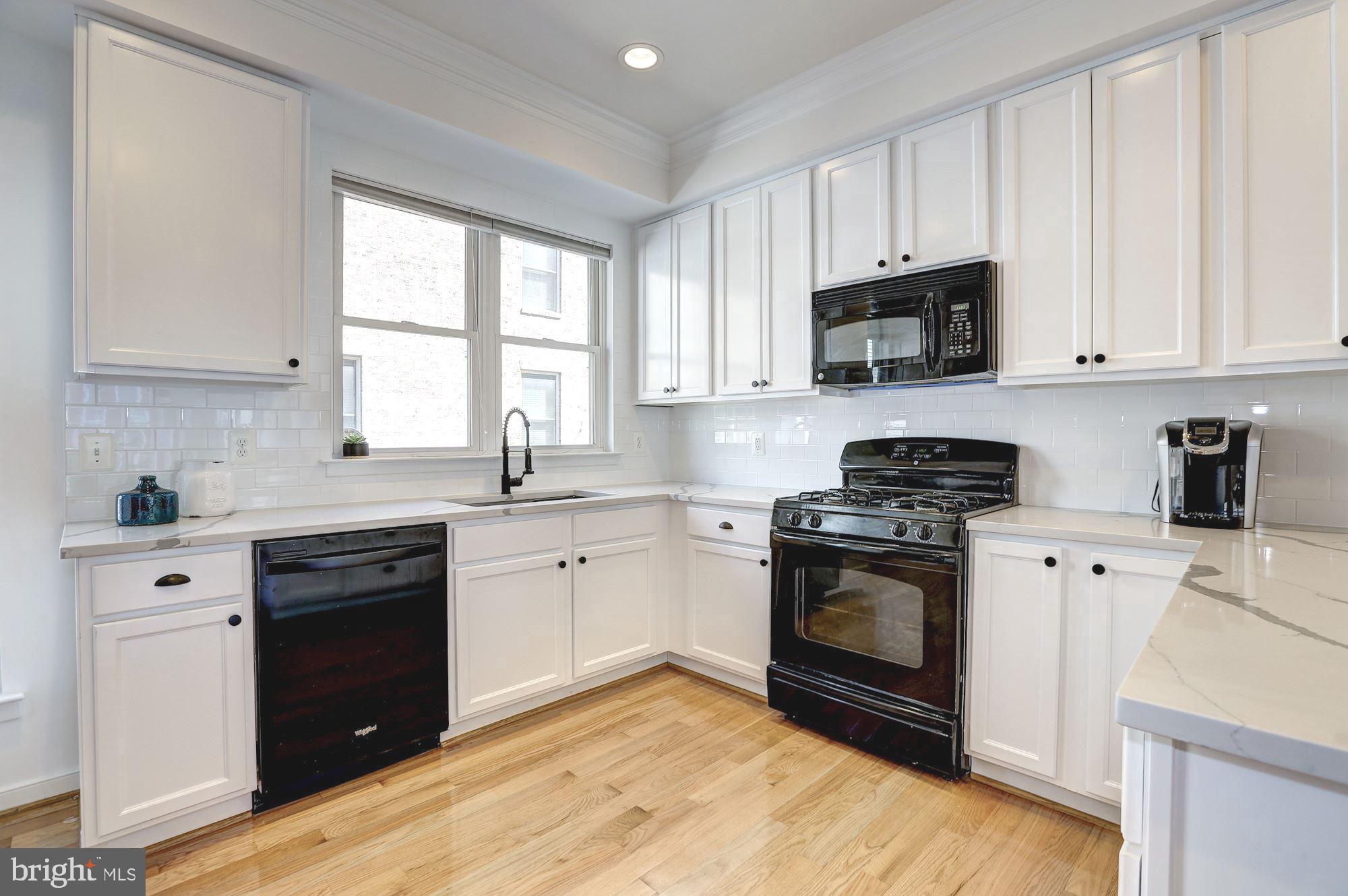 410 L Street Southeast Washington, DC 20003 - Photo 8 of 35 a kitchen with stainless steel appliances granite countertop a stove a sink and white cabinets