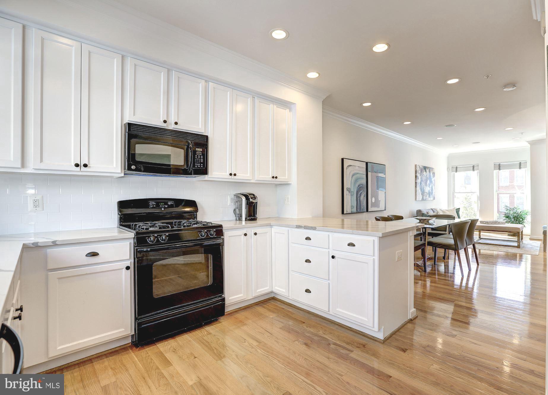 410 L Street Southeast Washington, DC 20003 - Photo 9 of 35 a kitchen with granite countertop white cabinets and stainless steel appliances