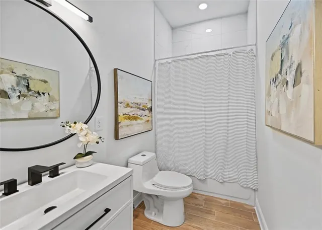 a bathroom with a sink mirror vanity and toilet