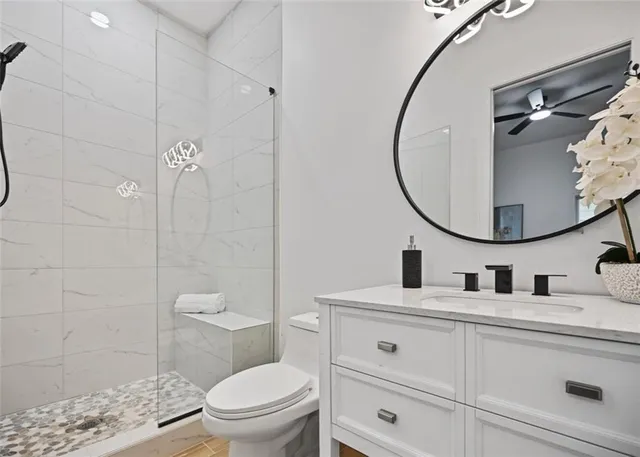 a bathroom with a toilet sink vanity and mirror