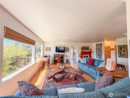a living room with furniture fireplace and a large window