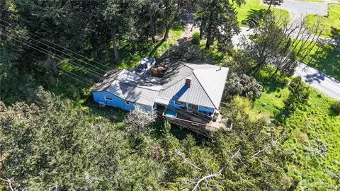 an aerial view of a house with a yard table and chairs