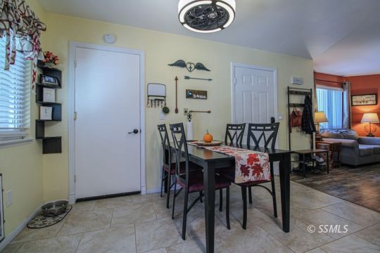 324 Sims Street Ridgecrest, CA 93555 - Photo 10 of 40 a view of a dining room and livingroom with furniture wooden floor a rug and a painting
