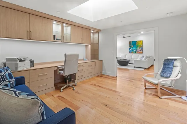 a view of a workspace with furniture and wooden floor