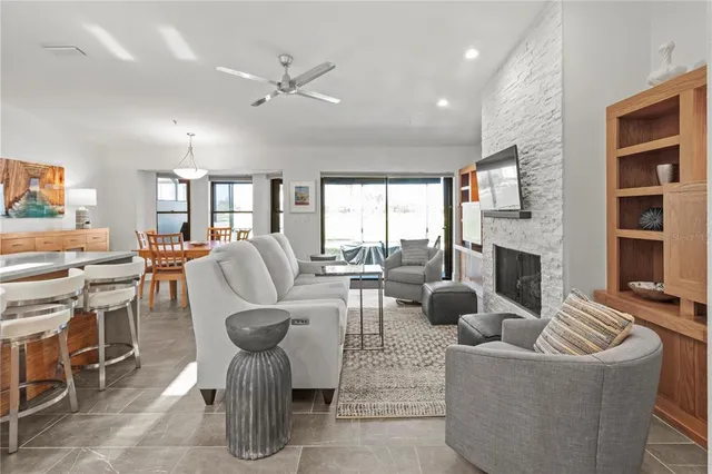 a living room with furniture a fireplace and a large window