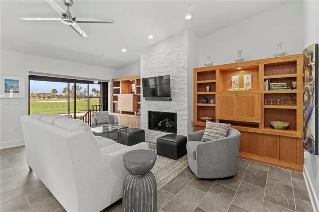 a living room with fireplace furniture and a large window