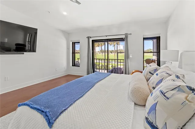 a spacious bedroom with a bed and a flat screen tv