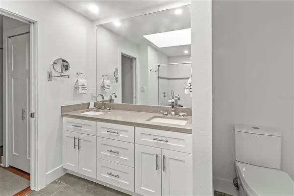 a bathroom with a granite countertop sink a toilet and shower