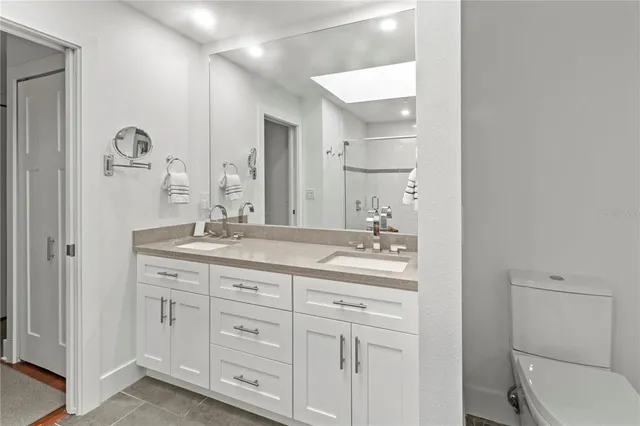 a bathroom with a granite countertop sink a toilet and shower