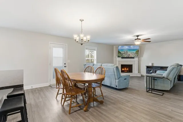 a dining room with furniture a chandelier and wooden floor