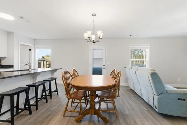 a dining room with furniture a chandelier and wooden floor