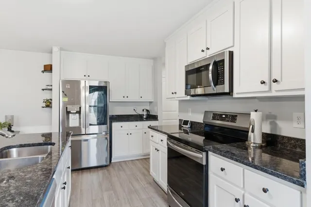 a kitchen with stainless steel appliances granite countertop a refrigerator sink and stove