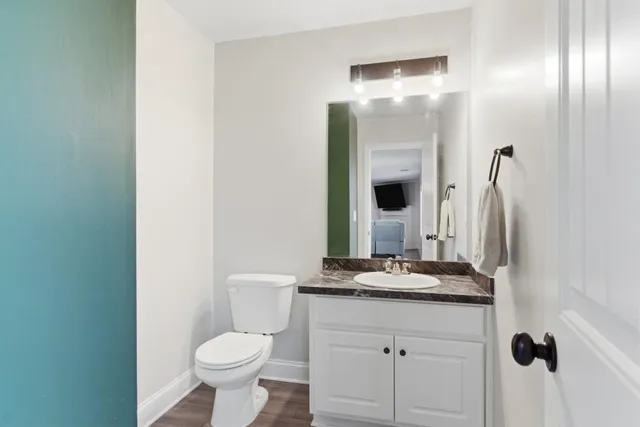 a bathroom with a granite countertop toilet sink and mirror