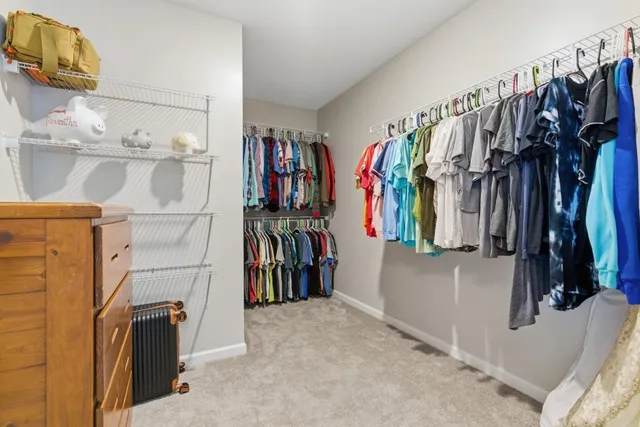 a view of walk in closet with clothes and shoes