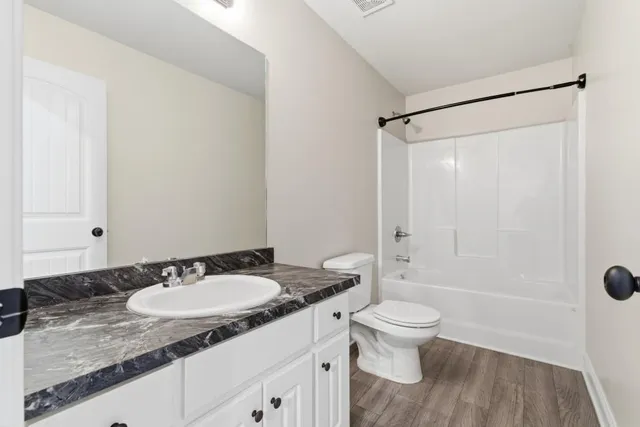 a bathroom with a granite countertop sink toilet and shower