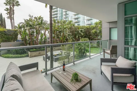a view of a roof deck with couches and potted plants
