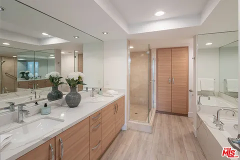 a spacious bathroom with a double vanity sink a mirror and shower