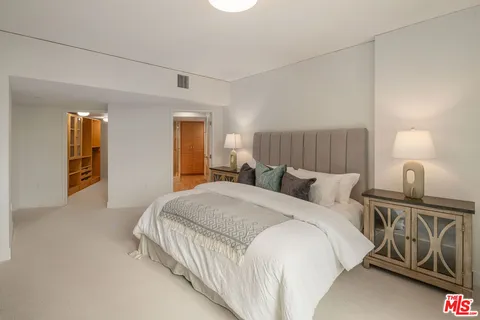 a bedroom with a bed and dresser with mirror