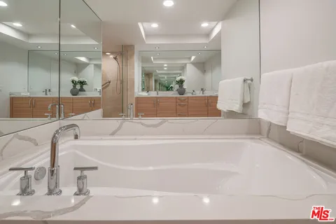 a bathroom with a bathtub and a large mirror