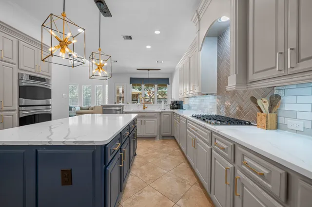 a kitchen with kitchen island granite countertop a sink a counter space appliances and cabinets