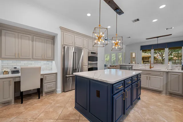 a kitchen that has a lot of cabinets in it and stainless steel appliances