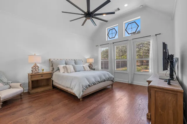 a bedroom with a bed and a desk with wooden floor