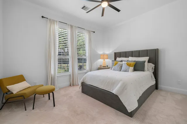 a bedroom with a bed a chair and a large window