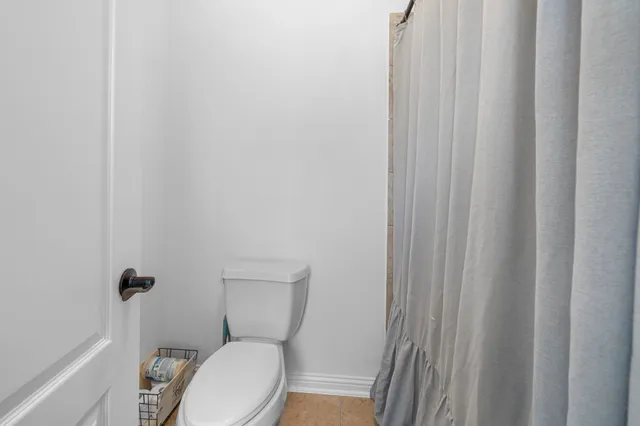 a white toilet sitting next to a shower curtain