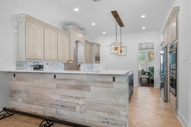 a view of a kitchen with kitchen island a counter top space appliances and cabinets