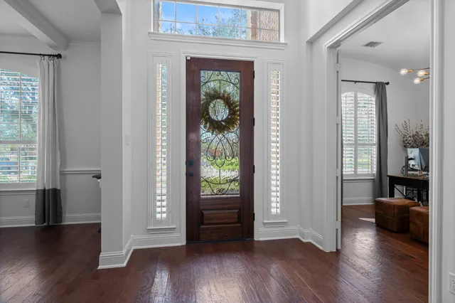 a view of a hallway with wooden floor and a bedroom